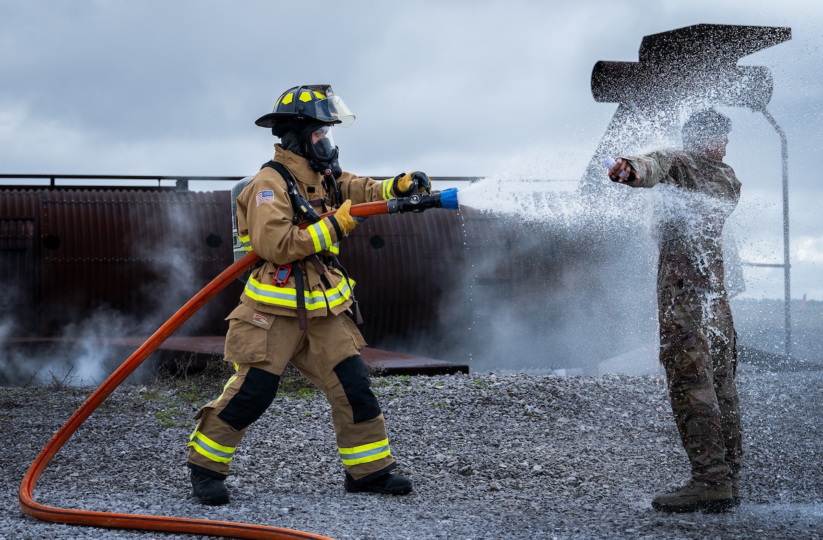 Senior Airman Axel Rojas, 96th Civil Engineer Group, hoses down Airman Aaron Patrimonio, 96th Medical Group, during mass casualty exercise Ready Eagle March 6, 2024, at Eglin Air Force Base, Fla. The exercise scenario had 96th MDG medics and firefighters respond to an explosion and take simulated casualties through the entire medical process, from triage and decontamination to higher-level care. (U.S. Air Force photo by Samuel King Jr.)