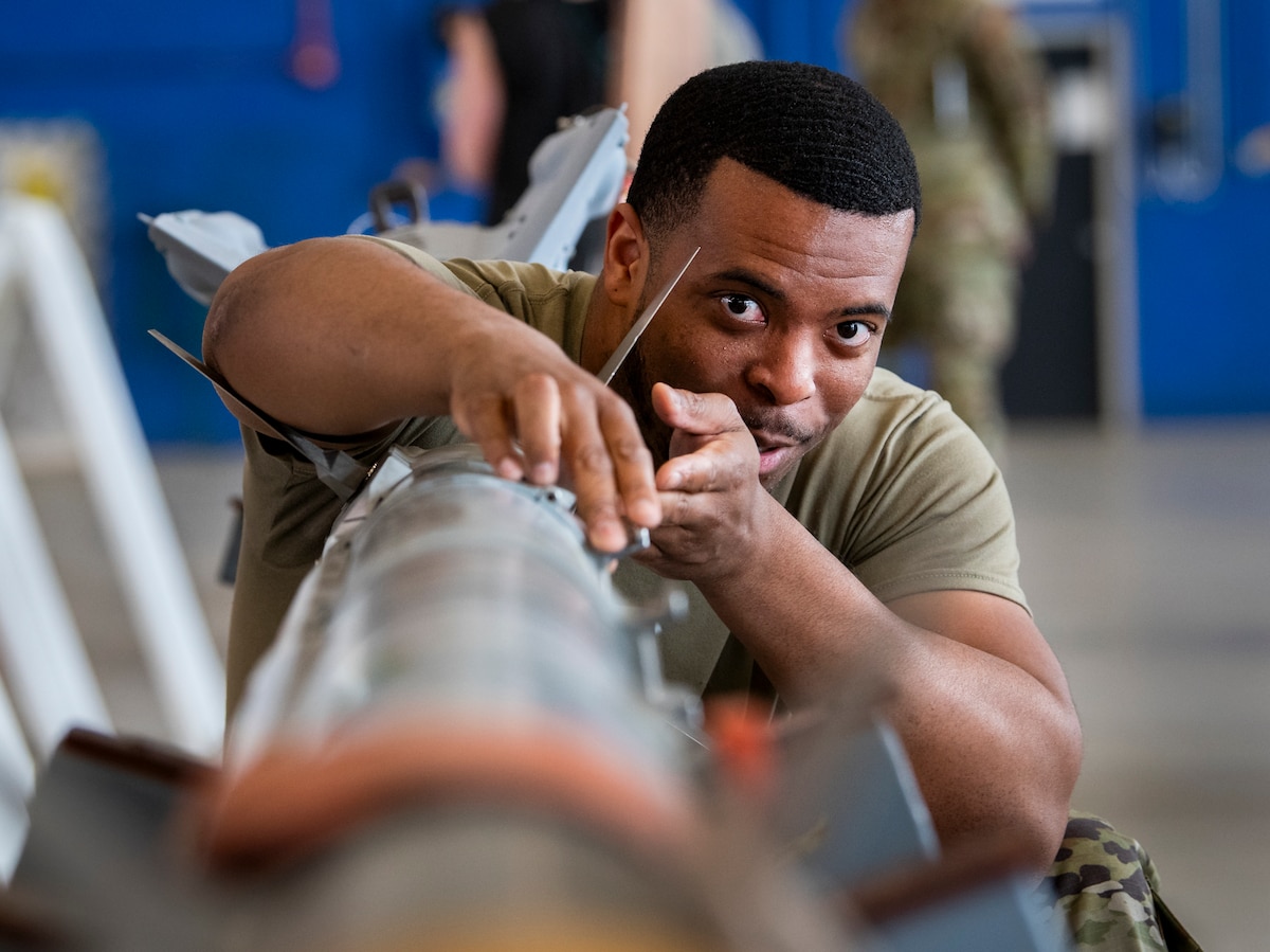 Senior Airman Quanteris Guy, 96th Aircraft Maintenance Squadron Red, examines an AIM-9 missile during the annual weapons load competition at Eglin Air Force Base, Fla., March 8, 2024. The quick-paced competition pitted the F-16 Fighting Falcon Blue team against the F-15 Eagle Red team in a test of knowledge, proficiency, speed and skill for year-end bragging rights. The winners will be announced during a ceremony in April. (U.S. Air Force photo by Samuel King Jr.)