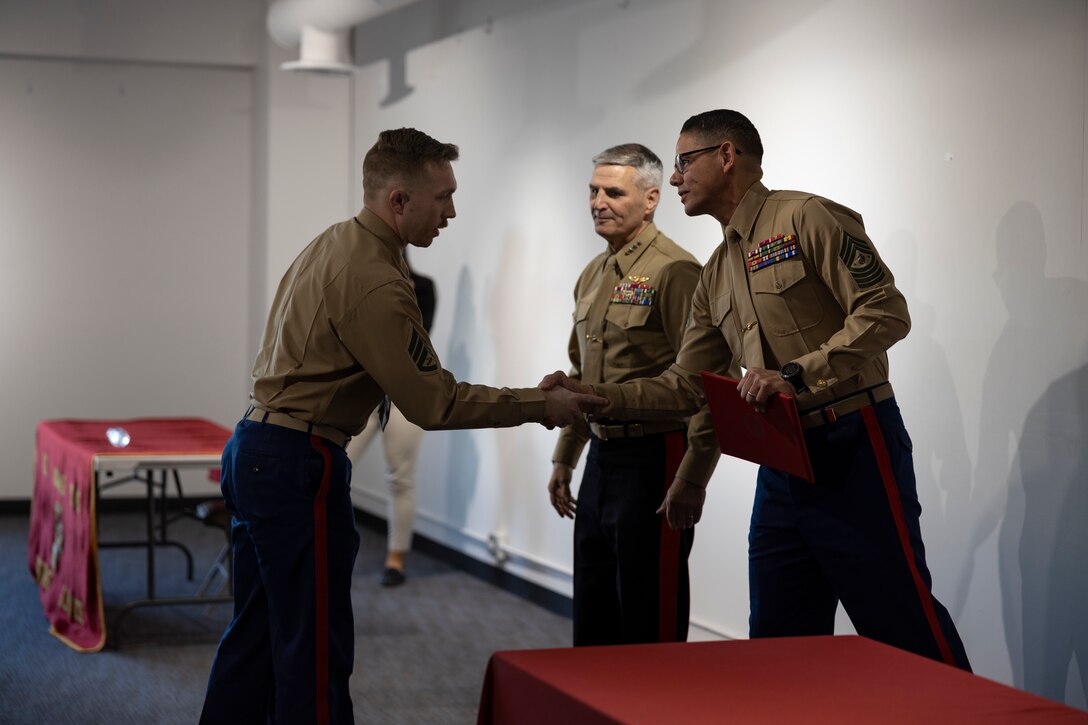 U.S. Marine Corps Gen. Christopher Mahoney, the Assistant Commandant of the Marine Corps and Sgt. Maj. Carlos Ruiz, the Sergeant Major of the Marine Corps, award Staff Sgt. Lane Kiehl with Recruiting Station Chicago, th e Navy Commendation Medal, Chicago, IL, Dec. 20, 2023. While Gen. Mahoney and Sgt. Maj. Ruiz visited RS Chicago and spoke with many recruiters they also had the chance to award Staff Sgt. Kiehl for his unwavering work ethic during his time as a recruiter. (U.S. Marine Corps photo by Sgt. Dalton J. Payne)