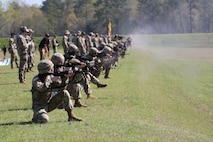 Multiple men in U.S. Army uniforms on outdoor rifle range.