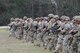 Multiple men in U.S. Army uniforms on outdoor rifle range.