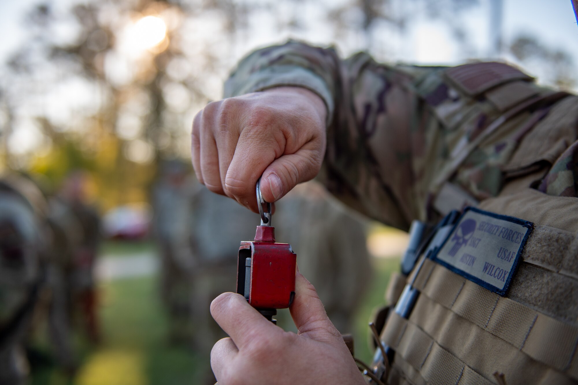 An Airman tightens a blank firing adapter on a training weapon