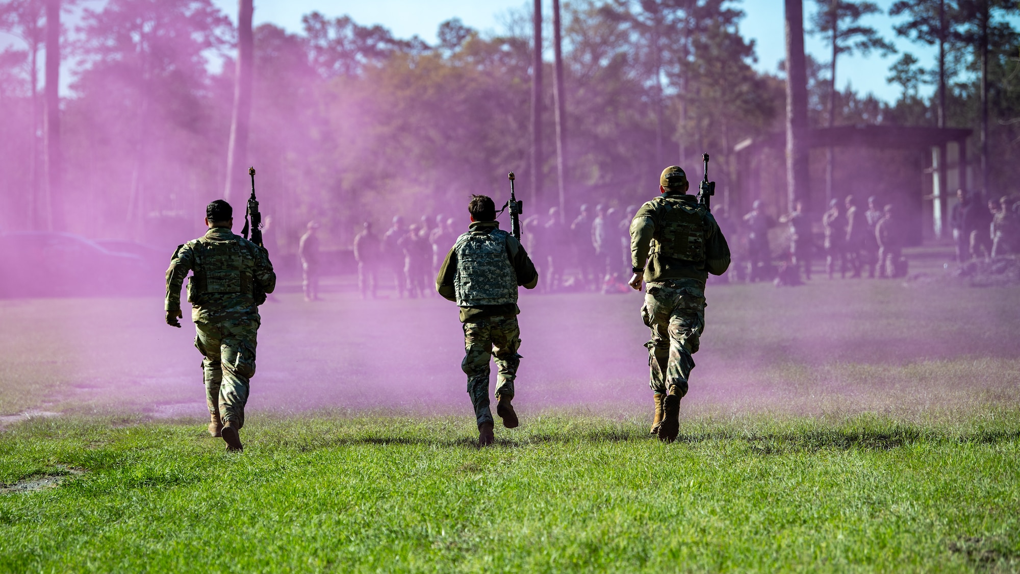 Moody Airmen run into a field with purple smoke