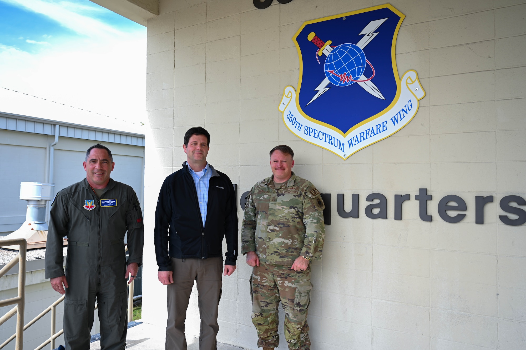 U.S. Air Force Col. Josh Koslov, 350th Spectrum Warfare Wing commander, left, Dr. John Plumb, Assistant Secretary of Defense for Space Policy, center, and U.S. Air Force Chief Master Sgt. Will Cupp, 350th SWW command chief, right, pose for a photo at the conclusion of a wing tour at Eglin Air Force Base, Fla., March 11, 2024. Plumb visited to the 350th SWW to learn about its mission to deliver adaptive and cutting-edge electromagnetic spectrum capabilities that provide the warfighter a tactical and strategic competitive advantage and freedom to attack, maneuver, and defend. (U.S. Air Force photo by Capt. Benjamin Aronson)