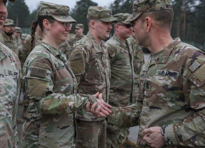 Command Sgt. Maj. Jesse Withers, Kentucky's state command sergeant major, gives out a coin to Army Sgt. Dorothy Ellis, a truck driver with the 2113th Transportation Company, during he and the Adjutant Generals visit to Poland Feb. 27, 2024.