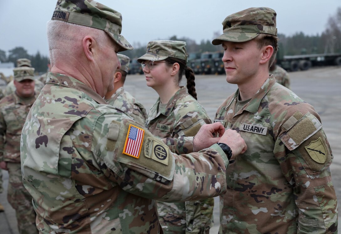 Army Maj. Gen. Haldane Lamberton, Adjutant General-Kentucky, promotes Army Sgt. Peter Shoyat, a truck driver with the 2113th Transportation Company, to sergeant during his visit to his unit that is currently deployed to Poland Feb. 27, 2024
