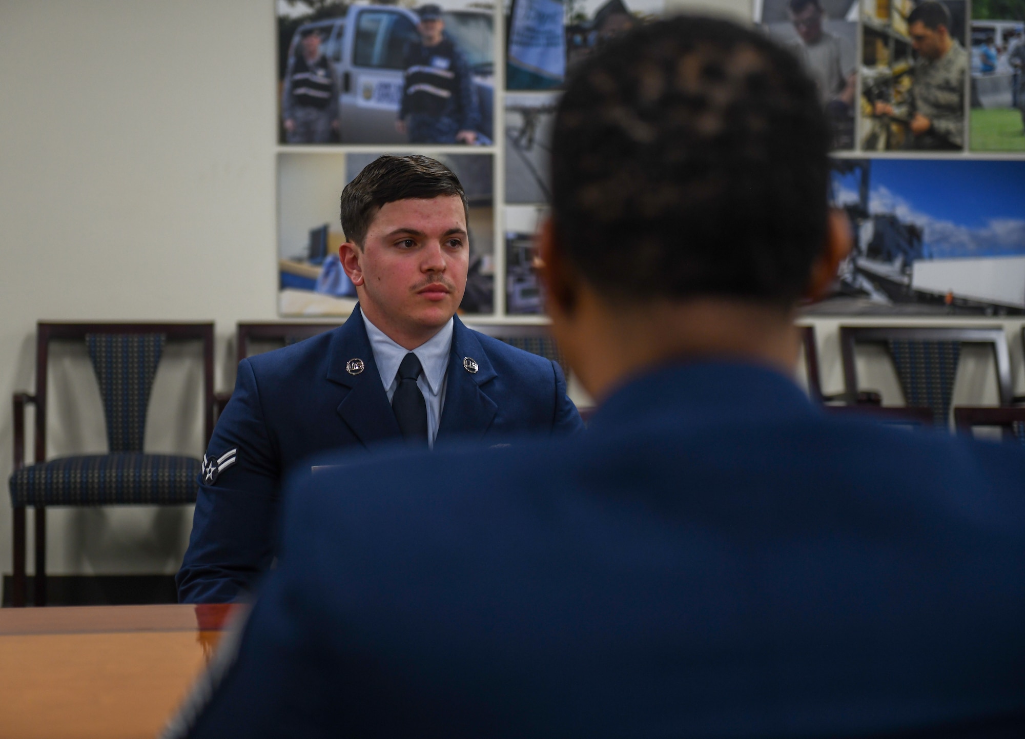 An Airman listens to other Airmen
