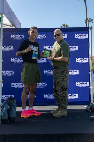 U.S. Marine Corps Sgt. Santiago Ryce, a student with recruiter school, Recruit Training Regiment is awarded for being the 1st place male for the St. Patrick's Day 5k fun run held at Marine Corps Recruit Depot San Diego, California, Mar. 15, 2024. The St. Patrick’s Day 5k fun run is one of many events hosted on the Depot designed to build unit morale and boost esprit de corps. (U.S. Marine Corps photo by Lance Cpl. Janell B. Alvarez)