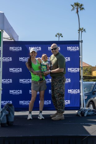 Annett Somogi-Leatige is awarded for being the 1st place female finisher for the St. Patrick's Day 5k fun run held at Marine Corps Recruit Depot San Diego, California, Mar. 15, 2024. The St. Patrick’s Day 5k fun run is one of many events hosted on the Depot designed to build unit morale and boost esprit de corps. (U.S. Marine Corps photo by Lance Cpl. Janell B. Alvarez)