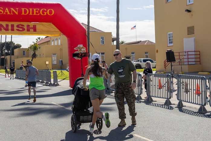 U.S. Marine Corps Col. Jason Freeby, commanding officer Headquarters and Service Battalion, congratulates runners finishing the St. Patrick's Day 5k fun run at Marine Corps Recruit Depot San Diego, California, March 15, 2024. The St. Patrick’s Day 5k fun run is one of many events hosted on the Depot designed to build unit morale and boost esprit de corps. (U.S. Marine Corps photo by Lance Cpl. Janell B. Alvarez)