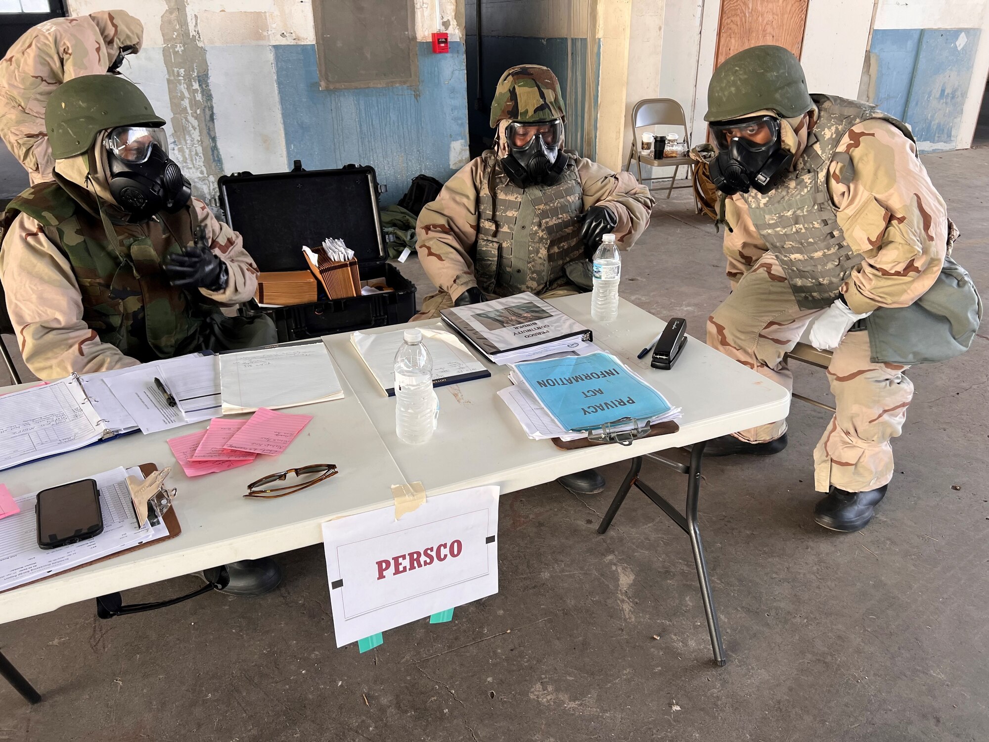 Airmen in chemical suits work