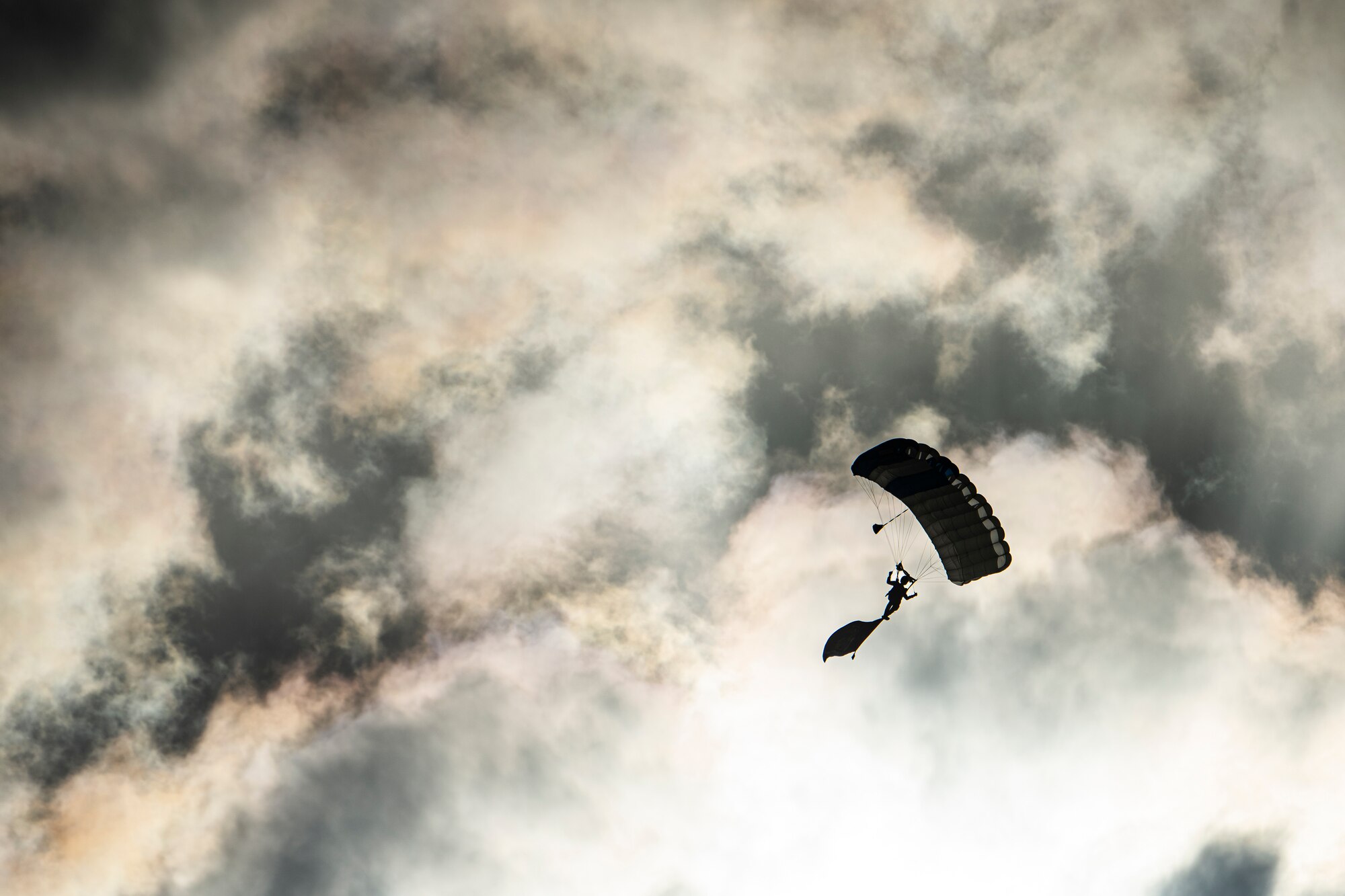 a parachutist descending from the sky