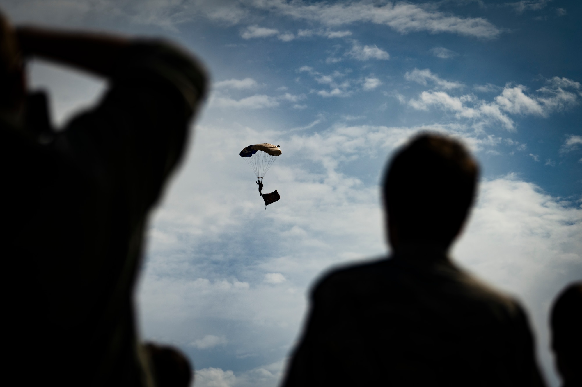a parachutist descending from the sky