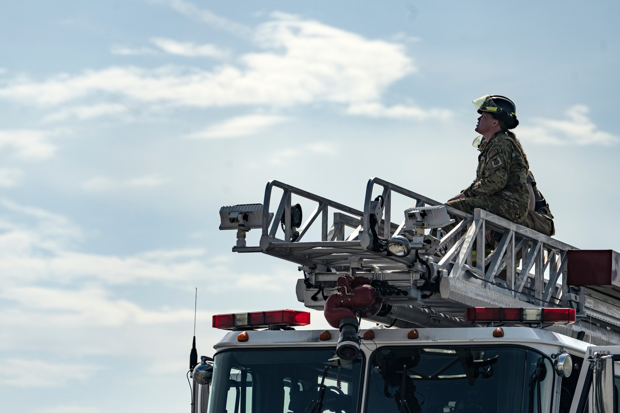 a firefighter sitting on top of a fire truck