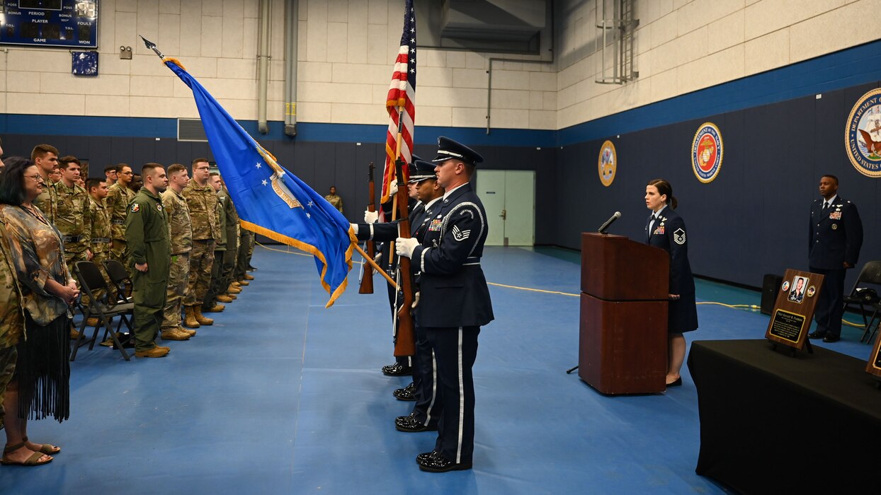 U.S. Air Force Airmen of the 17th Training Wing Base Honor Guard present the colors at the 316th Training Squadron Plaque Dedication Ceremony to honor Technical Sgt. Ernest R. Parrish and Staff Sgt. Jacob M. Galliher, at the Mathis Gymnasium, Goodfellow Air Force Base, Texas, March 15, 2024. Master Sgt. Jessica Abad, 316th Training Squadron instructor, sang the National Anthem during the presentation of the colors. (U.S. Air Force Photo by Airman 1st Class Evelyn J. D’Errico)