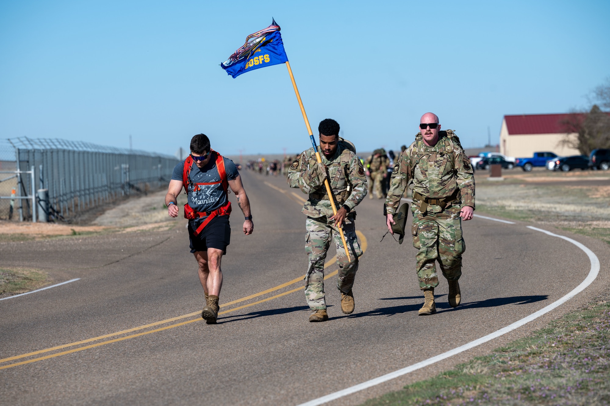 U.S. Air Force Staff Sgt. Anthony Simon, 27th Special Operations Security Forces Squadron quality control evaluator, carries the 27 SOSFS guidon during the 3rd Annual Steadfast Ruck March at Cannon Air Force Base, N.M., March 22, 2024. Members from the local community waited at the finish line during the event and experienced what it means to be part of The Steadfast Line. (U.S. Air Force photo by 2nd Lt. Charles Moye)