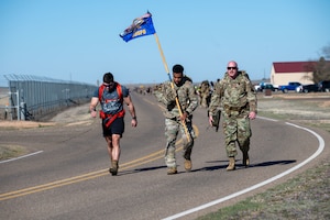 U.S. Air Force Staff Sgt. Anthony Simon, 27th Special Operations Security Forces Squadron quality control evaluator, carries the 27 SOSFS guidon during the 3rd Annual Steadfast Ruck March at Cannon Air Force Base, N.M., March 22, 2024. Members from the local community waited at the finish line during the event and experienced what it means to be part of The Steadfast Line. (U.S. Air Force photo by 2nd Lt. Charles Moye)