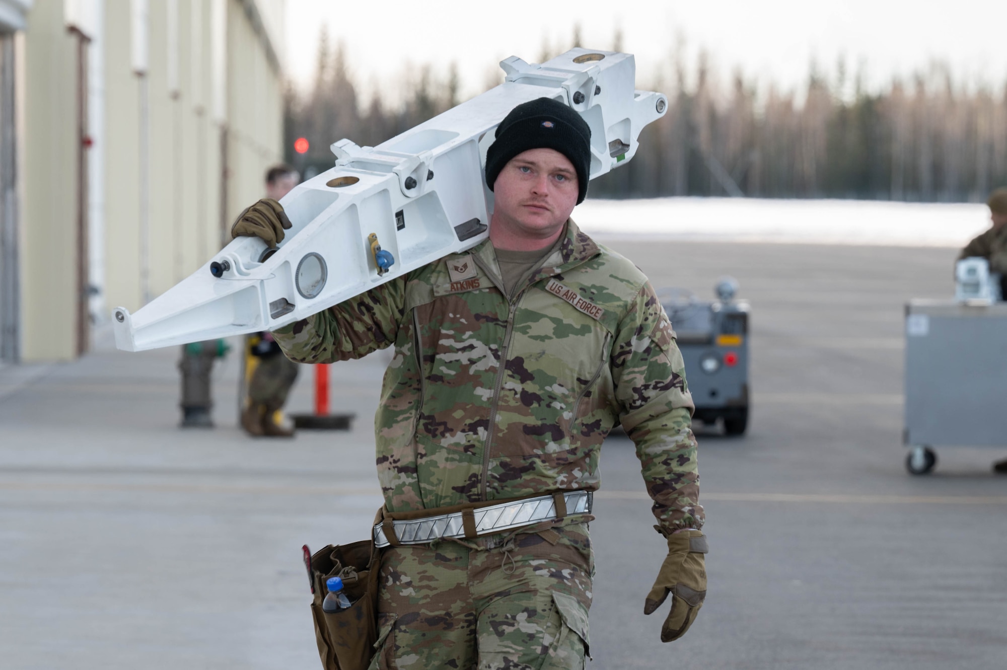 U.S. Air Force Staff Sgt. Andy Atkins, 355th Fighter Generation Squadron weapons load crew chief, carries loading equipment during Arctic Gold 24-2 at Eielson Air Force Base, Alaska, March 20, 2024.