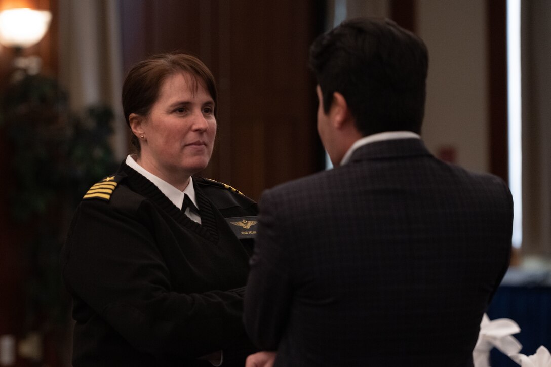 U.S. Navy Capt. Page Felini, left, Naval Air Facility Washington commanding officer, speaks with a guest during an honorary commander induction ceremony at Joint Base Andrews, Md., March 21, 2024.
