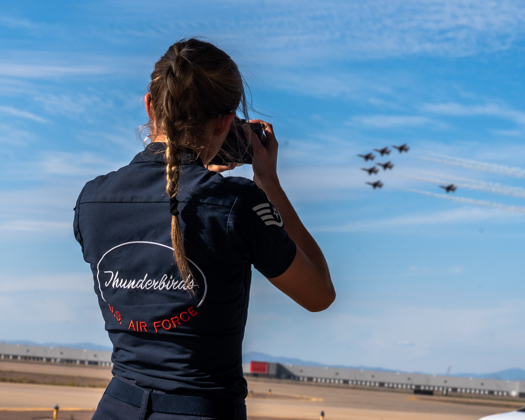 An Airman assigned to the U.S. Air Force Demonstration team, the "Thunderbirds," watch a demonstration during the Luke Days airshow on March 22, 2024, at Luke Air Force Base, Arizona.