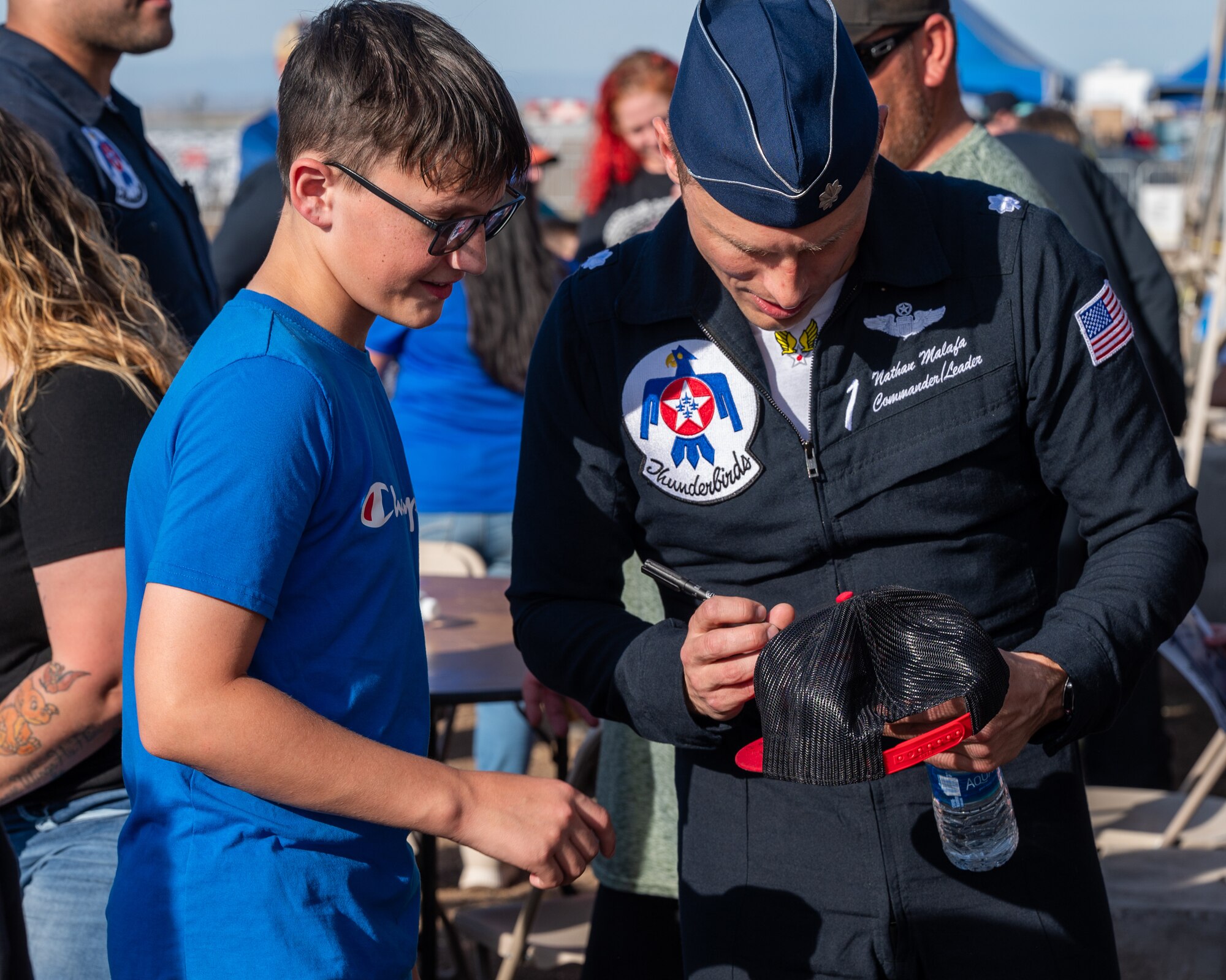 U.S. Air Force Lt. Col. Nathan Malafa, U.S. Air Force Demonstration Squadron “Thunderbirds” commander and advanced pilot No. 1, signs a ball-cap for a Make-a-Wish Foundation participant following a demonstration during the Luke Days airshow on March 22, 2024, at Luke Air Force Base, Arizona.