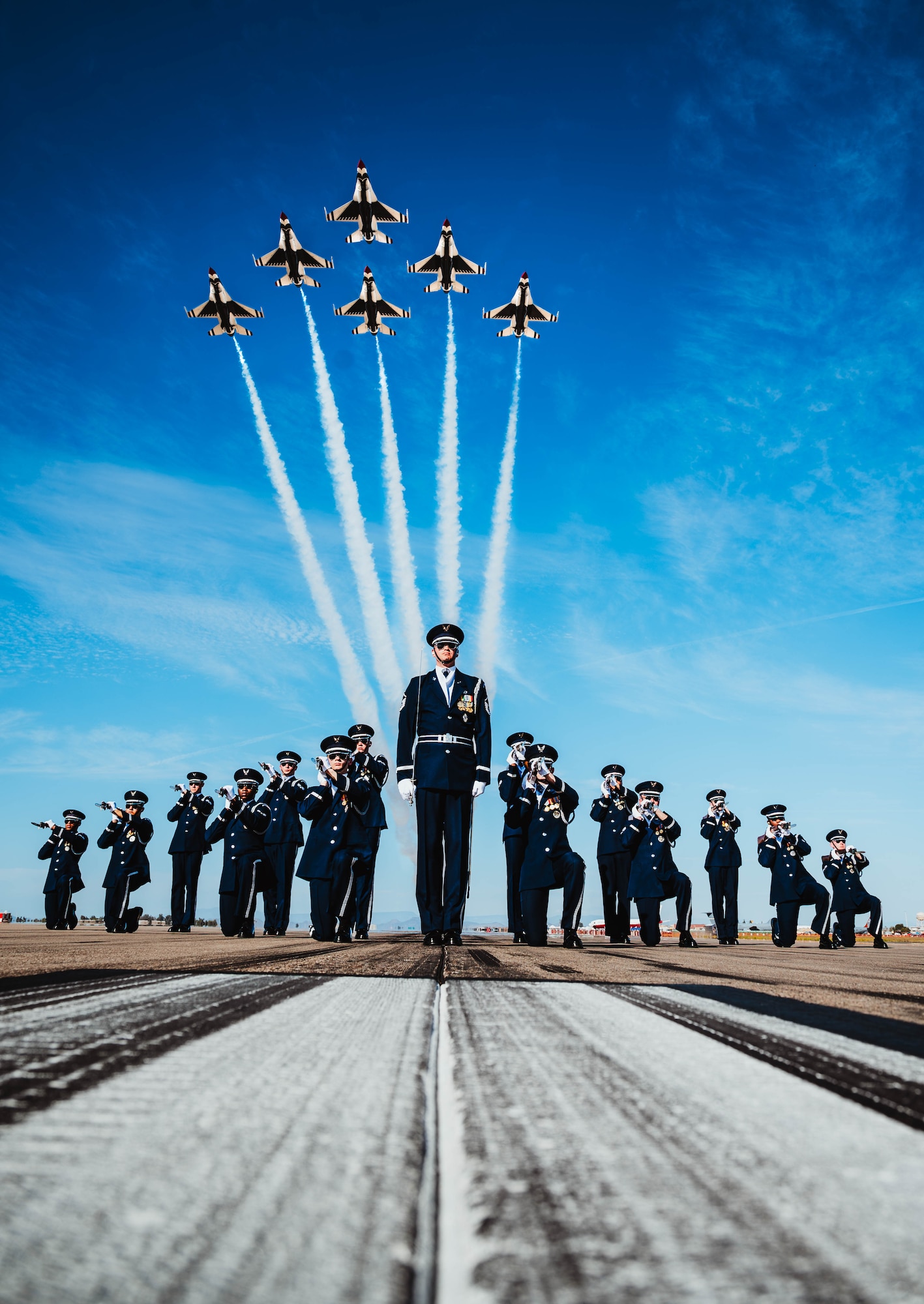 The U.S. Air Force Honor Guard executes a "ready-in" formation while U.S. Air Force F-16 Fighting Falcons, assigned to the U.S. Air Demonstration team, the "Thunderbirds," perform a diamond formation flyover overhead.