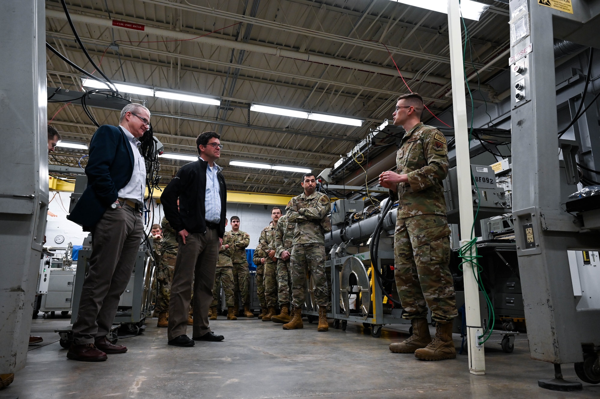 Dr. John Plumb, Assistant Secretary of Defense for Space Policy, receives a brief from U.S. Air Force Staff Sgt. Matthew Berg, 36th Electronic Warfare Squadron EW systems journeyman, during a tour of the 350th Spectrum Warfare Wing at Eglin Air Force Base, Fla., March 11, 2024. The pods are used in testing mission data files that allow aircraft to sense, identify, locate, and counter electronic warfare threats. (U.S. Air Force photo by Capt. Benjamin Aronson)