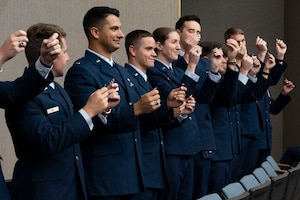 Student pilots of Class 24-07 Undergraduate Pilot Training hold up their broken wings during their graduation ceremony at Laughlin Air Force Base, Texas, March 22, 2024. The “breaking of the wings” is a tradition said to bring good fortune throughout a pilot’s career. One half of the wings is kept by the new pilot, and the other half is given to someone of significance in their lives. (U.S. Air Force photo by Senior Airmen Kailee Reynolds)