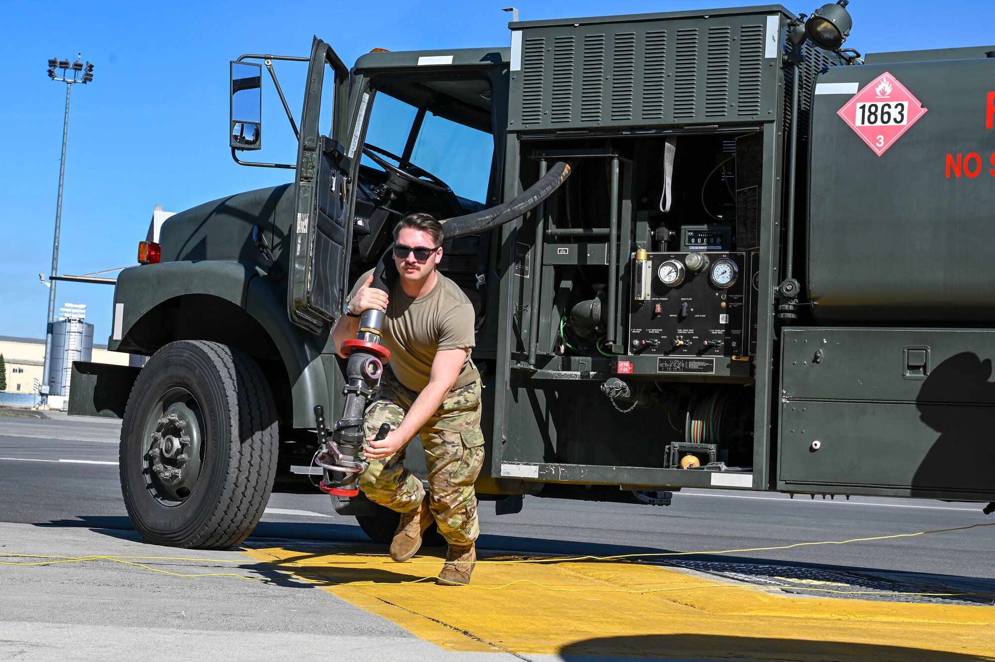 Airman carries fuels hose