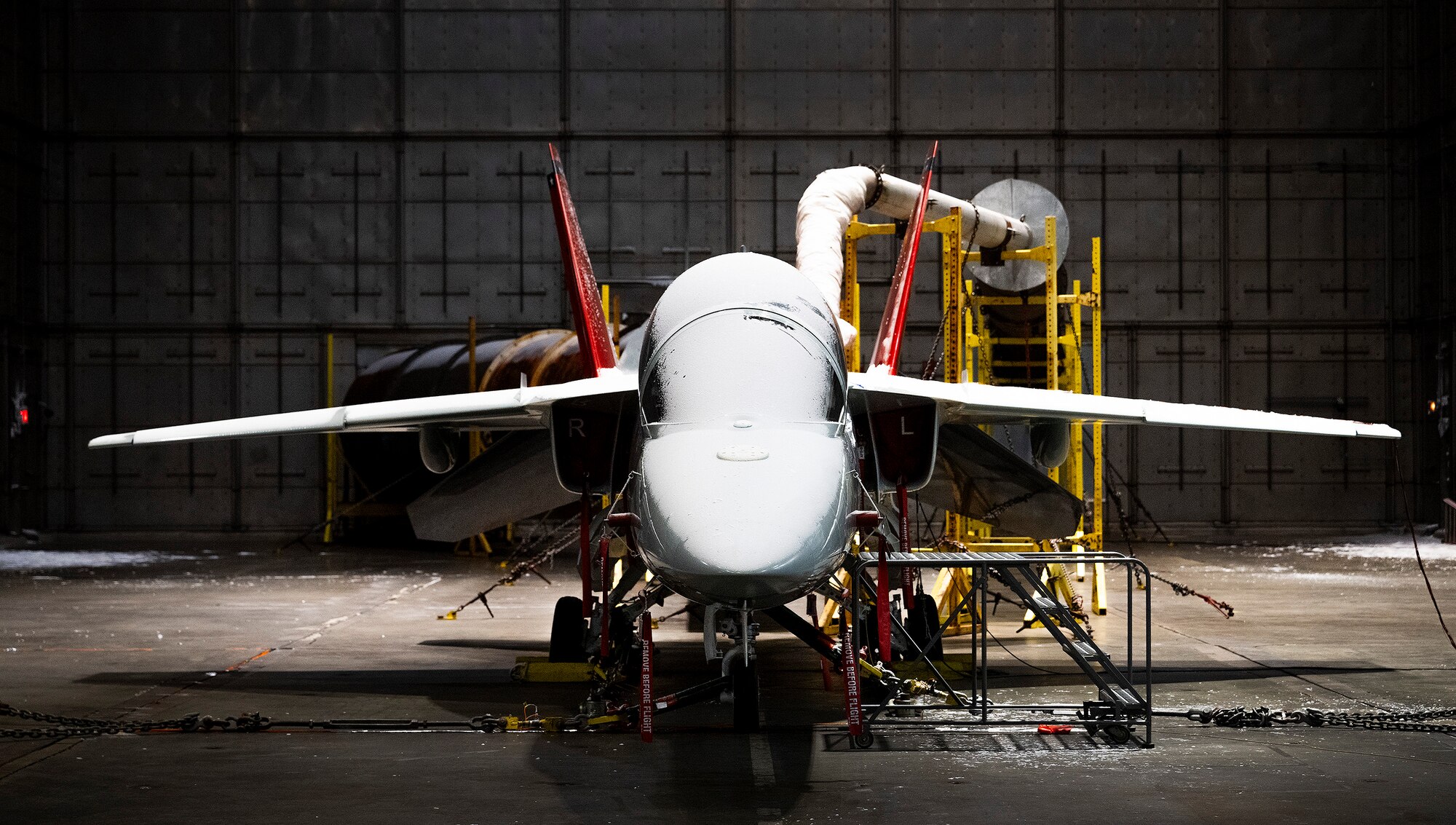 A T-7A Red Hawk sits in a frozen McKinley Climatic Lab chamber Jan. 22, 2024 at Eglin Air Force Base, Florida. The Air Force’s newest training aircraft experienced temperature extremes from 110 to minus 25 degrees Fahrenheit as well as heavy humidity during the month of testing. The tests evaluate how the aircraft, its instrumentation and electronics fared under the extreme conditions it will face in the operational Air Force. (U.S. Air Force photo by Samuel King Jr.)