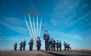 The U.S. Air Force Honor Guard stands in formation as F-16 Fighting Falcons, assigned to the U.S. Air Force Demonstration team, the "Thunderbirds," pass above them prior to Luke Days 2024 on March 22, 2024, at Luke Air Force Base, Arizona.