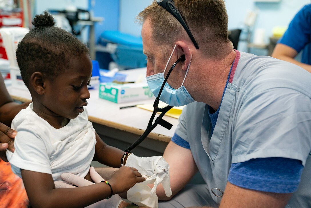 U.S. Air Force Maj. James Oliver, 349th Medical Squadron nurse, examines a patient