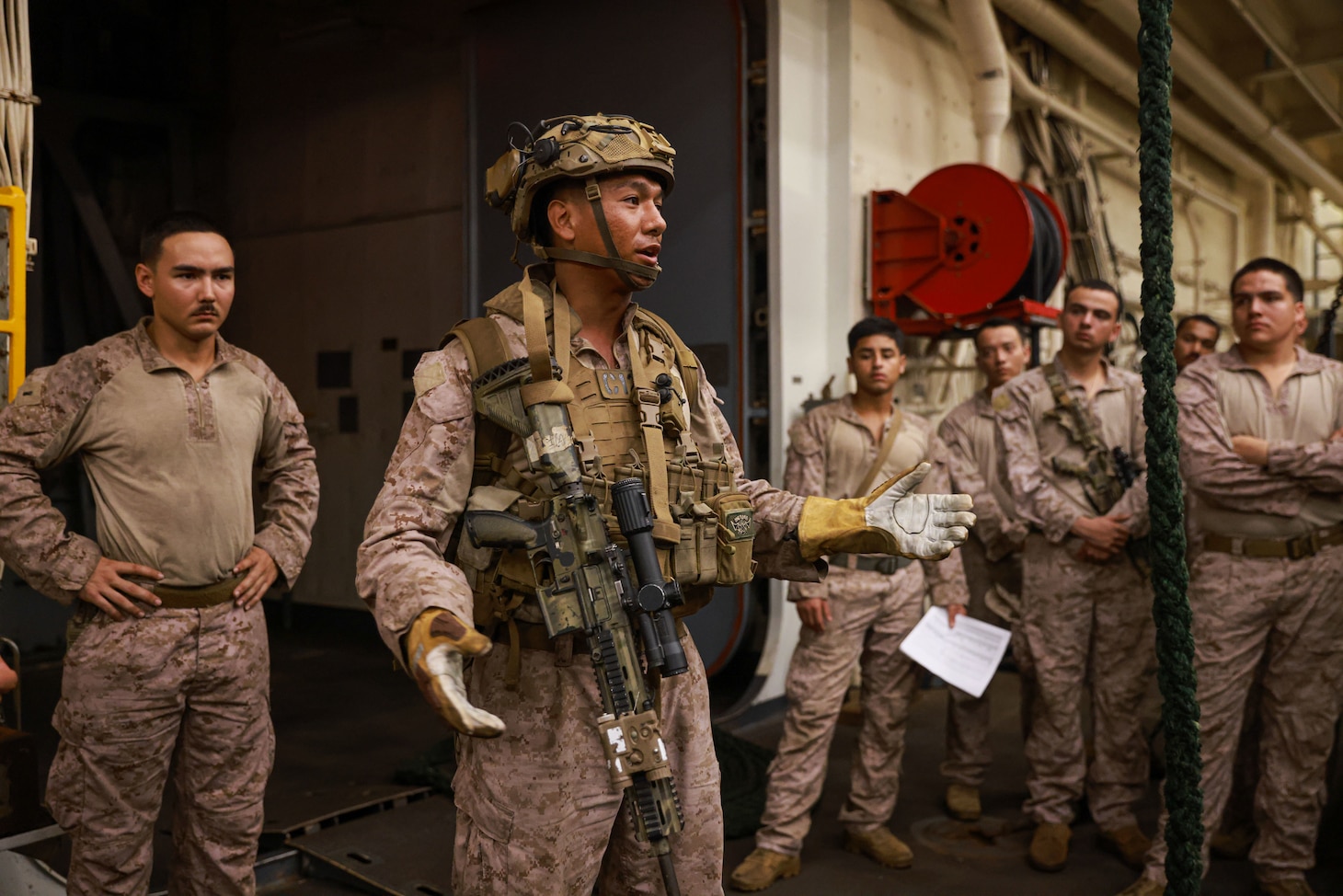 U.S. Marine Corps Sgt. Samuel Ricario, a squad leader and fast-rope master assigned to Charlie Company, Battalion Landing Team 1/5, 15th Marine Expeditionary Unit, briefs dismounting procedures prior to fast-rope training aboard the amphibious transport dock USS Somerset (LPD 25) during Exercise Tiger TRIUMPH in Visakhapatnam, India, March 20, 2024. Tiger TRIUMPH is a U.S.-India tri-service amphibious exercise focused on humanitarian assistance and disaster relief readiness and interoperability. Tiger TRIUMPH enables U.S. and Indian Armed Forces to improve interoperability and bilateral, joint, and service readiness in the Indian Ocean region and beyond to better achieve mutual regional security objectives. (U.S. Marine Corps photo by Cpl. Aidan Hekker)