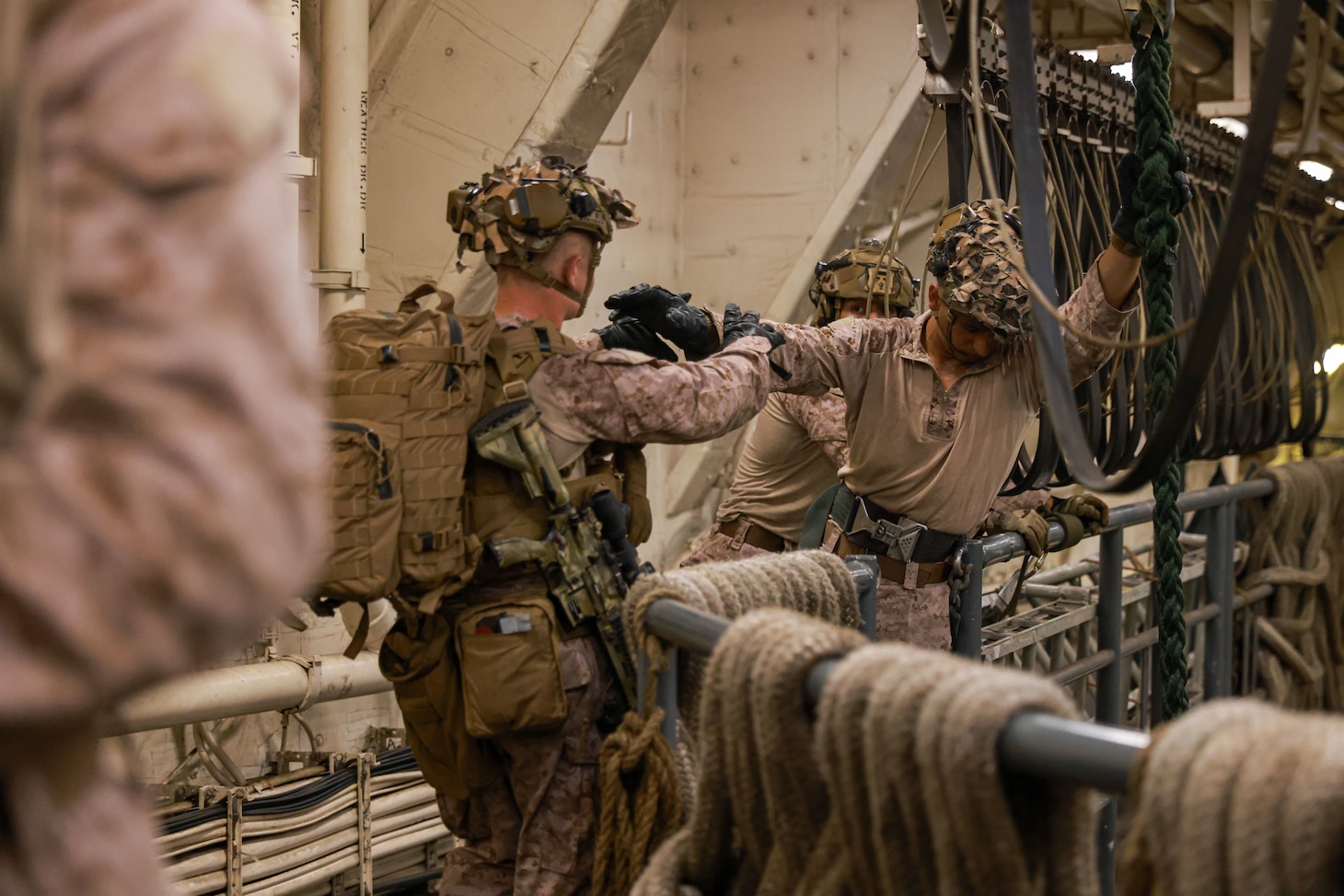 U.S. Marine Corps Cpl. Khuaja Shams, right, a fast-rope master assigned to Charlie Company, Battalion Landing Team 1/5, 15th Marine Expeditionary Unit, belays a Marine during fast-rope training aboard the amphibious transport dock USS Somerset (LPD 25) during Exercise Tiger TRIUMPH in Visakhapatnam, India, March 20, 2024. Tiger TRIUMPH is a U.S.-India tri-service amphibious exercise focused on humanitarian assistance and disaster relief readiness and interoperability. Tiger TRIUMPH enables U.S. and Indian Armed Forces to improve interoperability and bilateral, joint, and service readiness in the Indian Ocean region and beyond to better achieve mutual regional security objectives. (U.S. Marine Corps photo by Cpl. Aidan Hekker)
