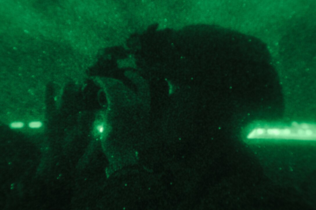 Japan Air Self-Defense Force Capt. Atsushi Kanda, an air traffic controller with Air Traffic Control Service Group, Air Support Command, uses a PVS-14 night vision monocular device during a training exercise at Marine Corps Air Station Iwakuni, Japan, Dec. 13, 2023.  The U.S. Air Force 36th Contingency Response Group conducted joint training that focused on equipment and process interoperability in a contested logistics environment with the MCAS Iwakuni Headquarters and Headquarters Squadron Logistics Department and members of the Japan Air Self-Defense Force.  (U.S. Marine Corps photo by Cpl. Darien Wright)