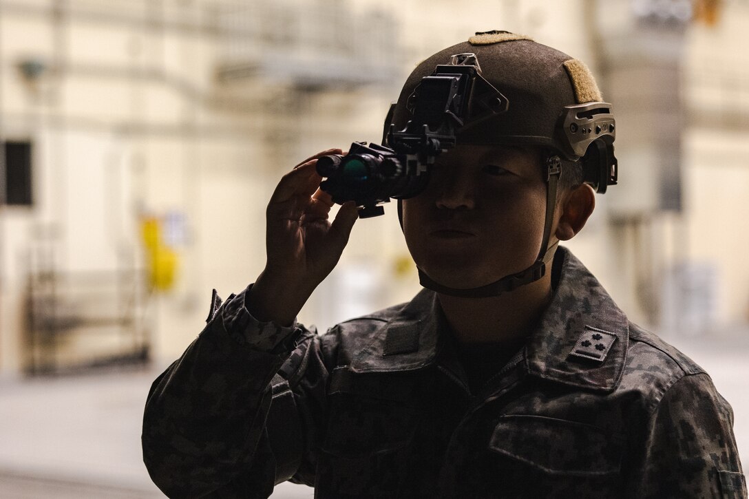 Japan Air Self-Defense Force Capt. Atsushi Kanda, an air traffic controller with Air Traffic Control Group, Air Support Command, uses a PVS-14 night vision monocular device during a training exercise at Marine Corps Air Station Iwakuni, Japan, Dec. 13, 2023.  The U.S. Air Force 36th Contingency Response Group conducted joint training that focused on equipment and process interoperability in a contested logistics environment with the MCAS Iwakuni Headquarters and Headquarters Squadron Logistics Department and members of the Japan Air Self-Defense Force.  (U.S. Marine Corps photo by Cpl. Darien Wright)