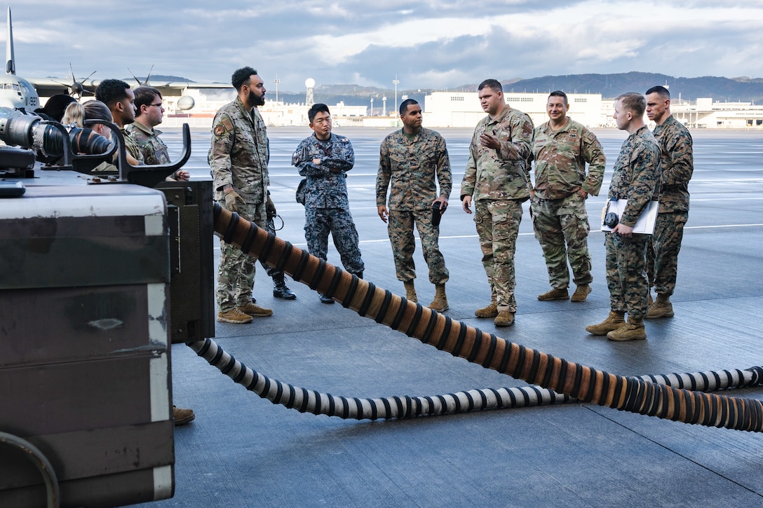 U.S. Air Force Staff Sgt. Ryan Merritt, center, an aerospace ground equipment specialist with the U.S. Air Force 36th Contingency Response Squadron, 36th Contingency Response Group, gives a class on the capabilities of an A/M32A-60A generator during a training exercise at MCAS Iwakuni, Japan, Dec. 12, 2023. The U.S. Air Force 36th Contingency Response Group conducted joint training that focused on equipment and process interoperability in a contested logistics environment with the MCAS Iwakuni Headquarters and Headquarters Squadron Logistics Department and members of the Japan Air Self-Defense Force.  (U.S. Marine Corps photo by Cpl. Darien Wright)