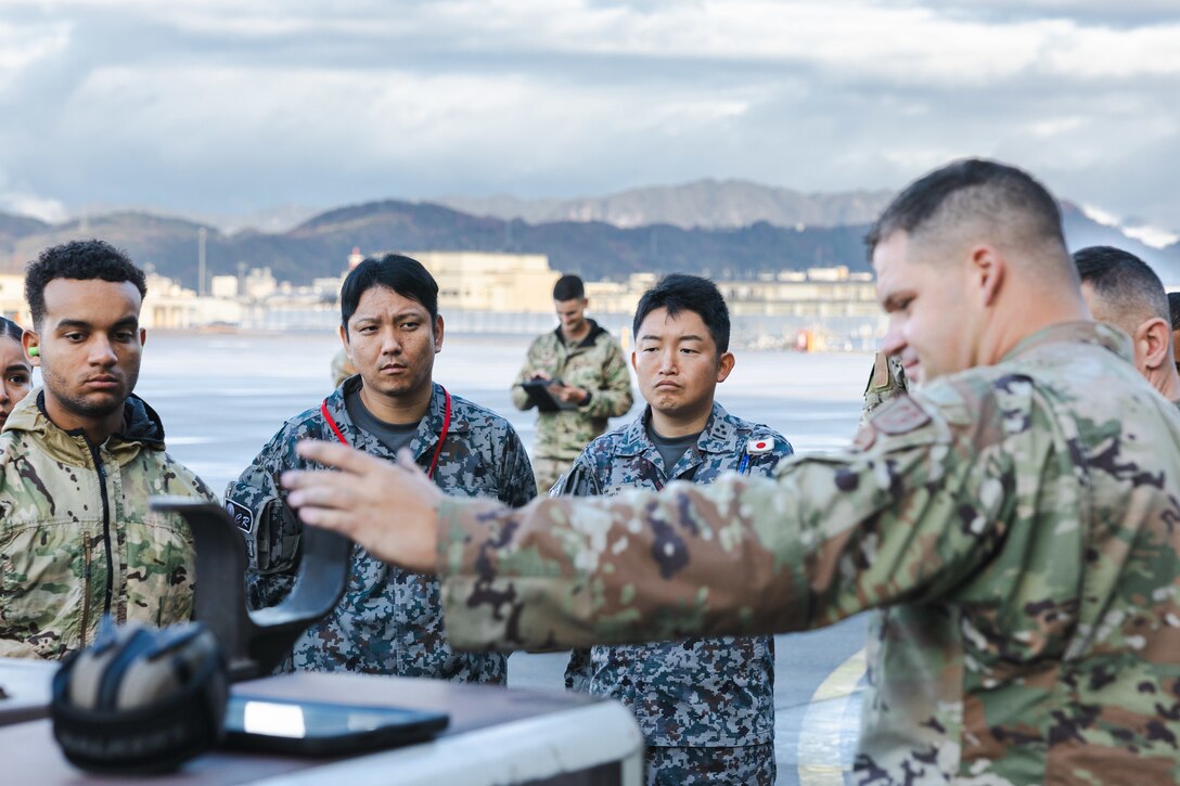 U.S. Air Force Staff Sgt. Ryan Merritt, an aerospace ground equipment specialist with the U.S. Air Force 36th Contingency Response Squadron, 36th Contingency Response Group, gives a class on the capabilities of an A/M32A-60A generator during a training exercise at MCAS Iwakuni, Japan, Dec. 12, 2023. The U.S. Air Force 36th Contingency Response Group conducted joint training that focused on equipment and process interoperability in a contested logistics environment with the MCAS Iwakuni Headquarters and Headquarters Squadron Logistics Department and members of the Japan Air Self-Defense Force.  (U.S. Marine Corps photo by Cpl. Darien Wright)