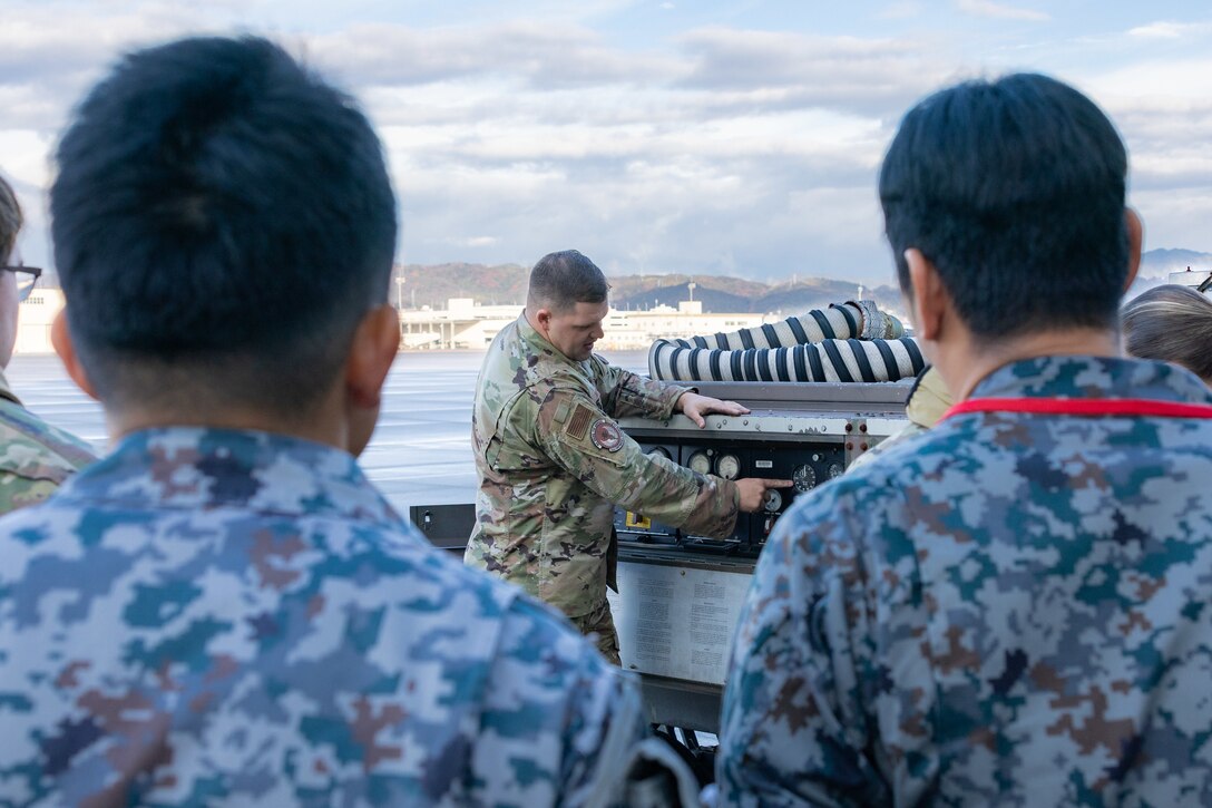 U.S. Air Force Staff Sgt. Ryan Merritt, an aerospace ground equipment specialist with the U.S. Air Force 36th Contingency Response Squadron, 36th Contingency Response Group, gives a class on the capabilities of an A/M32A-60A generator during a training exercise at MCAS Iwakuni, Japan, Dec. 12, 2023. The U.S. Air Force 36th Contingency Response Group conducted joint training that focused on equipment and process interoperability in a contested logistics environment with the MCAS Iwakuni Headquarters and Headquarters Squadron Logistics Department and members of the Japan Air Self-Defense Force.  (U.S. Marine Corps photo by Cpl. Darien Wright)