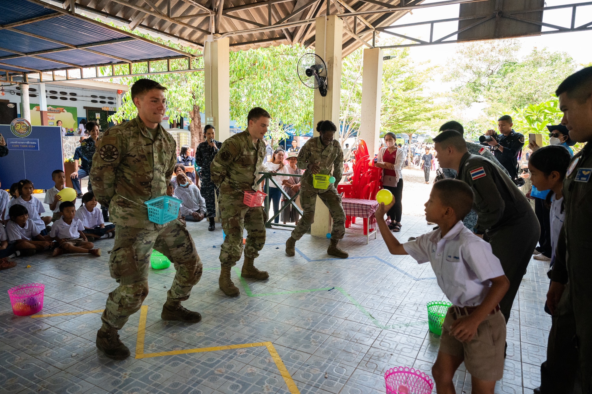 U.S. Air Force Airmen from the 356th Fighter Generation Squadron out of Eielson Air Force Base, Alaska, participate in a ball toss game during a community outreach event for Cope Tiger 2024, Ban Krok Duan Ha School, Nakhon Ratchasima Province, Thailand, March 21, 2024. The event was part of Cope Tiger which is an annual trilateral aerial exercise meant to enhance readiness and further develop interoperability. (U.S. Air Force photo by Tech. Sgt. Hailey Haux)