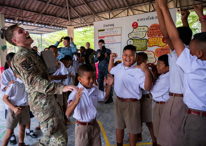 Senior Airman Jack Mitchell, 356th Fighter Generation Squadron crew chief out of Eielson Air Force Base, Alaska, plays rock, paper, scissors with students during a community outreach event for Cope Tiger 2024, Ban Krok Duan Ha School, Nakhon Ratchasima Province, Thailand, March 21, 2024. As part of the outreach event, U.S. Air Force Airmen participated in various activities like local games such as relay races, ball tosses, and a competitive game of rock, paper, scissors. (U.S. Air Force photo by Tech. Sgt. Hailey Haux)