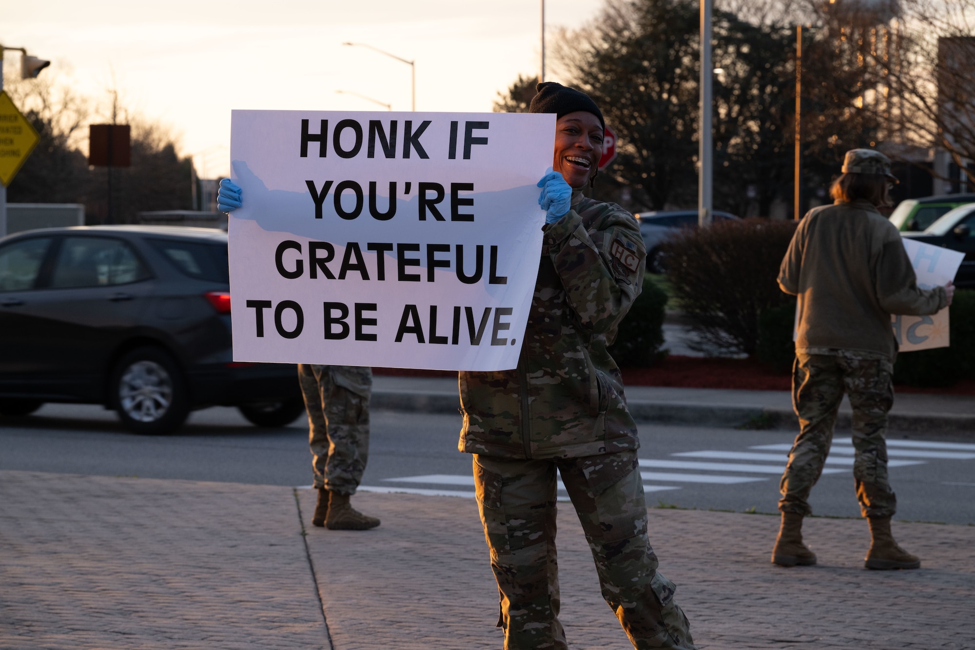 U.S. Air Force Staff Sgt. Deandria Hutcherson, 436th Airlift Wing religious affairs noncommissioned officer in charge of readiness, holds a positive affirmation sign at the main gate of Dover Air Force Base, Delaware, March 19, 2024. Hutcherson, along with members of Team Dover’s resilience team held up signs with encouraging messages as personnel drove through the installation gates. (U.S. Air Force photo by Airman 1st Class Dieondiere Jefferies)