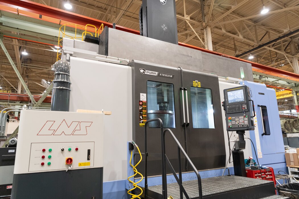 A wind tunnel nozzle is shaped inside the recently-acquired vertical turning center, or VTC, March 5, 2024, in the Arnold Air Force Base Model and Machine Shop at Arnold AFB, Tenn. The VTC operates similarly to a wood lathe except items are situated vertically on a rotating table within the machine chamber. As the piece rotates, carbide blades within the chamber are used to mill and grind until the piece is formed into the desired shape. The VTC was needed to accelerate the fabrication of various-sized nozzles to be installed in a wind tunnel at Arnold AFB, headquarters of Arnold Engineering Development Complex. (U.S. Air Force photo by Keith Thornburgh)