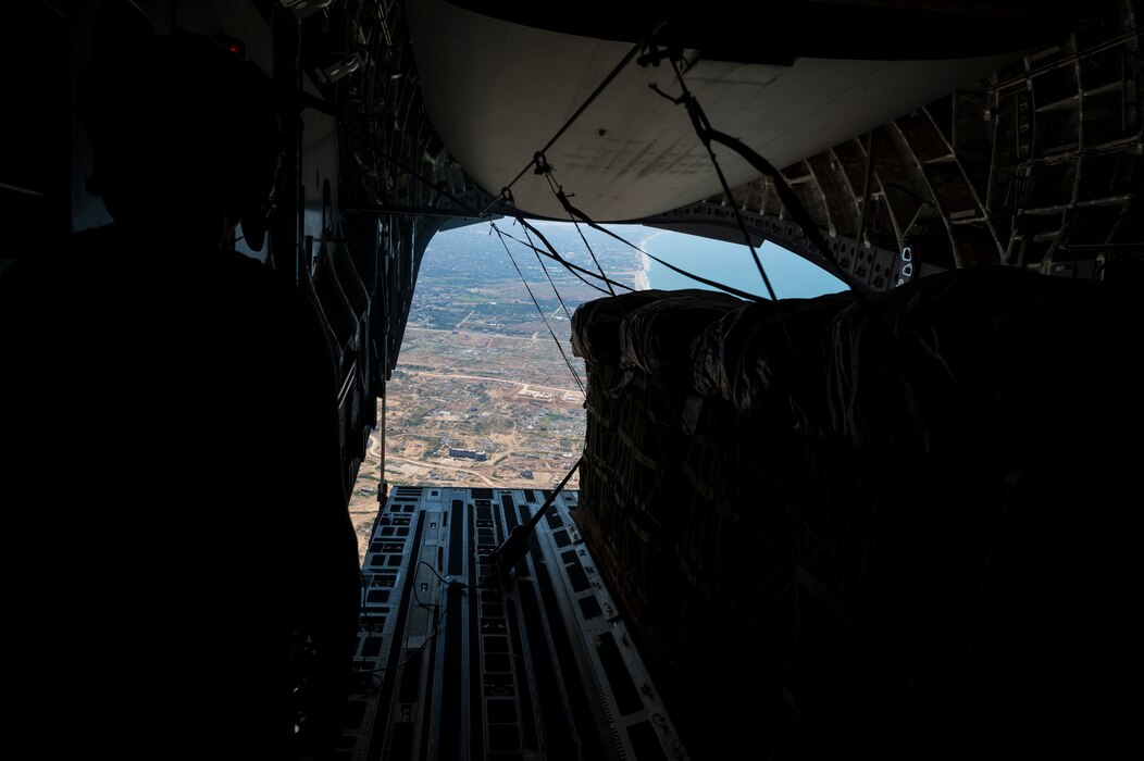 A loadmaster watches as humanitarian aid is airdropped from a C-17 over Gaza.