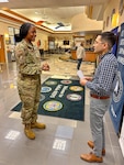 Air Force Staff Sgt. Courtney Rollins, Buffalo MEPS medical specialist non-commissioned officer, and Dr. Laurence Batmazian, Buffalo MEPS chief medical officer, collaborate outside the medical exam room of Buffalo MEPS. Buffalo MEPS is one of six MEPS testing a pilot that changes the workflow of medical prescreens for military applicants.