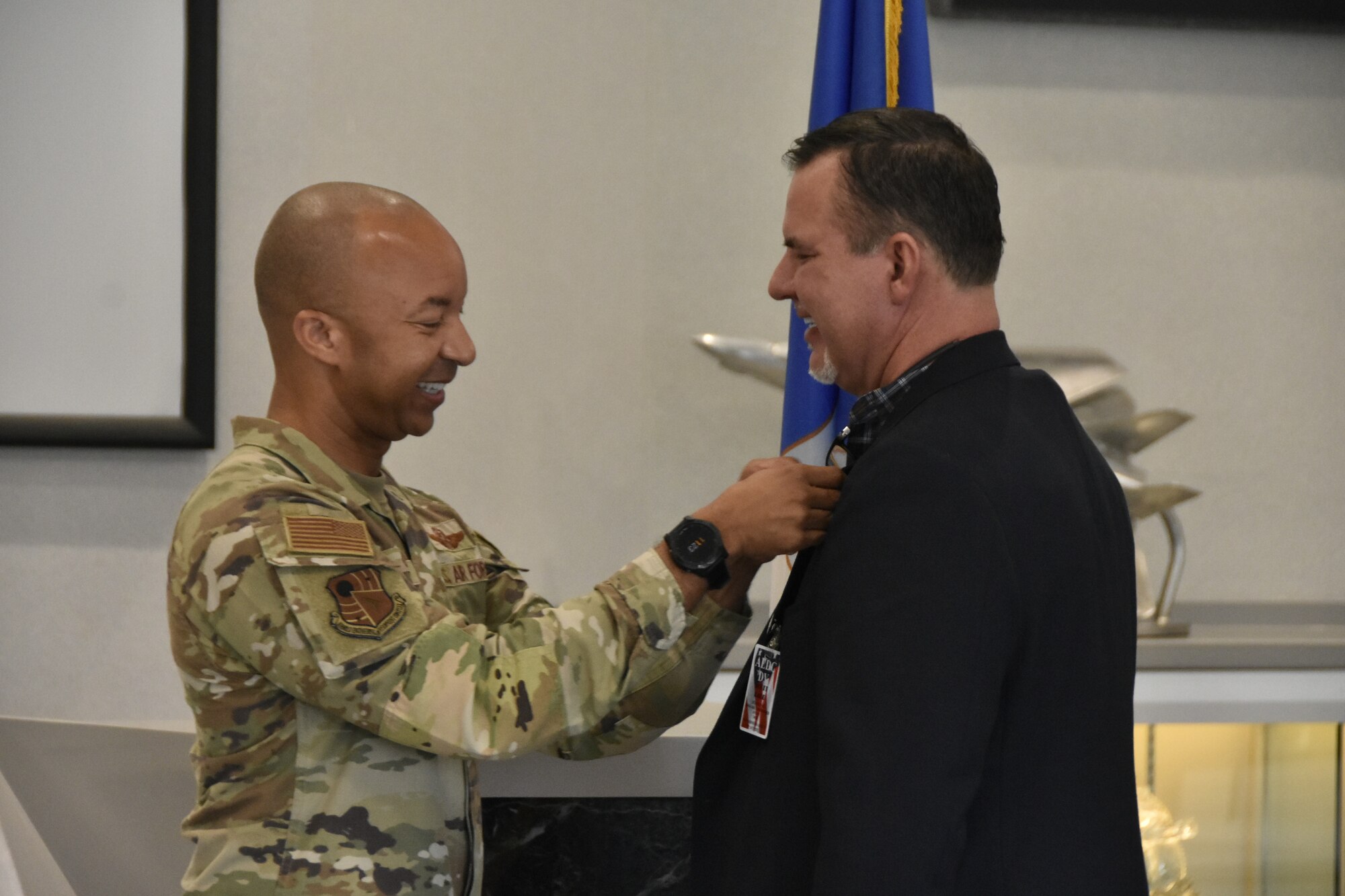 Scott Ladd, director of operations, Black Rifle Coffee Company, receives his Honorary Commander lapel pin from Col. Randel Gordon, commander, Arnold Engineering Development Complex at Arnold AFB, Tenn., during the March 8, 2024, Honorary Commander Induction Ceremony.