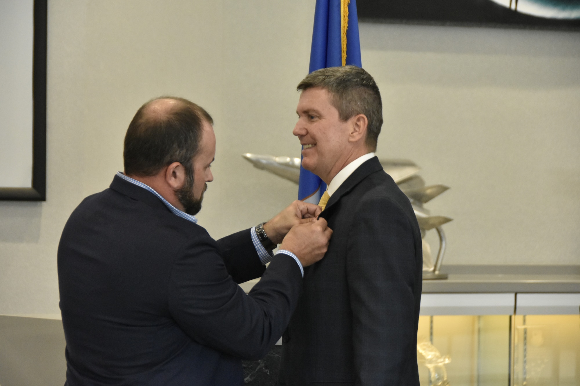 Winston Brooks, executive director, Tullahoma Area Economic Development Corporation, receives his Honorary Commander lapel pin from Joshua Meeks, director, 804th Test Support Squadron, during the March 8, 2024, Honorary Commander Induction Ceremony at Arnold Air Force Base, Tenn., headquarters of Arnold Engineering Development Complex.