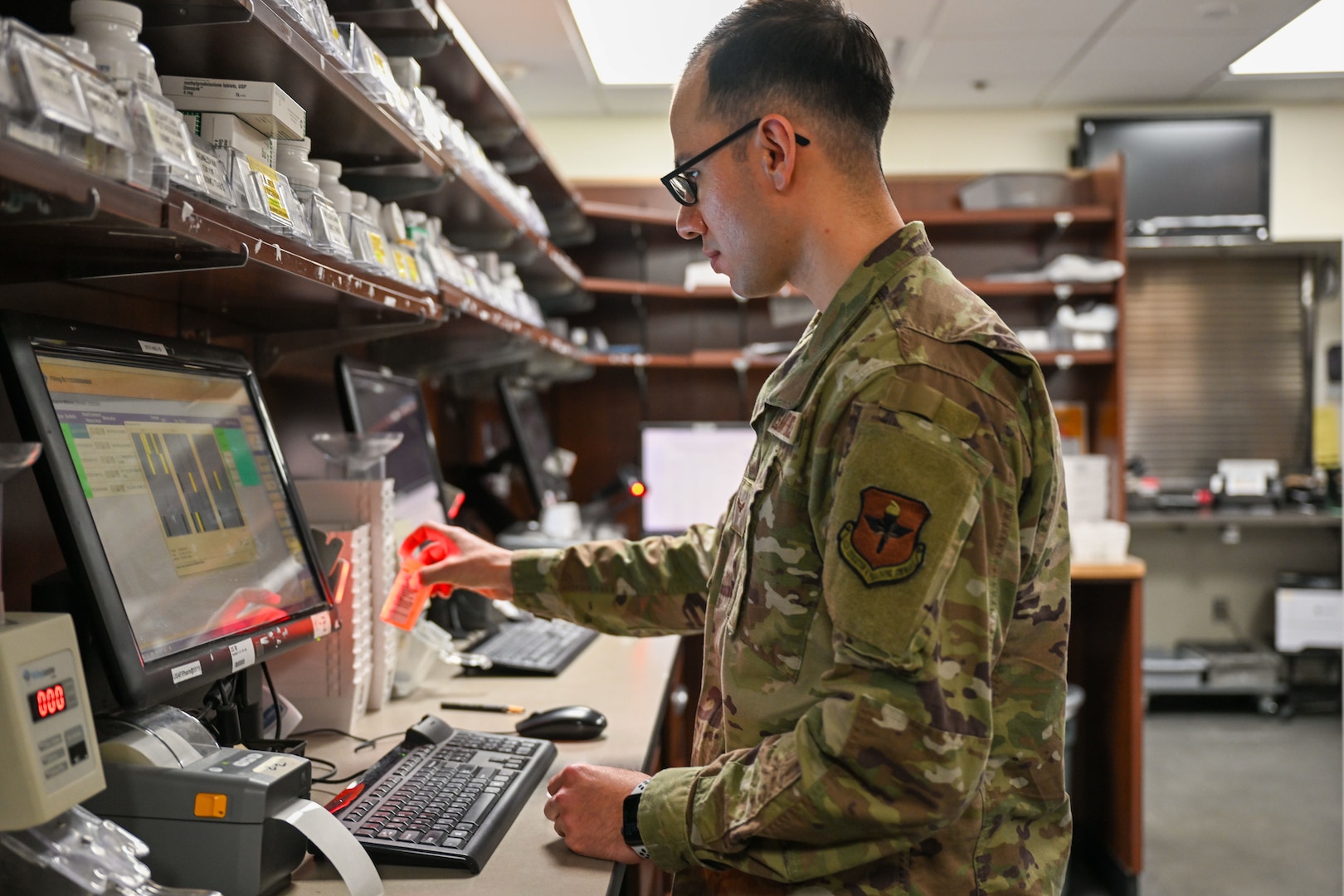 military pharmacy technician scans prescription bottle