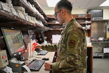 military pharmacy technician scans prescription bottle