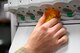 pharmacy technician's hand holds prescription bottle as medication dispenses